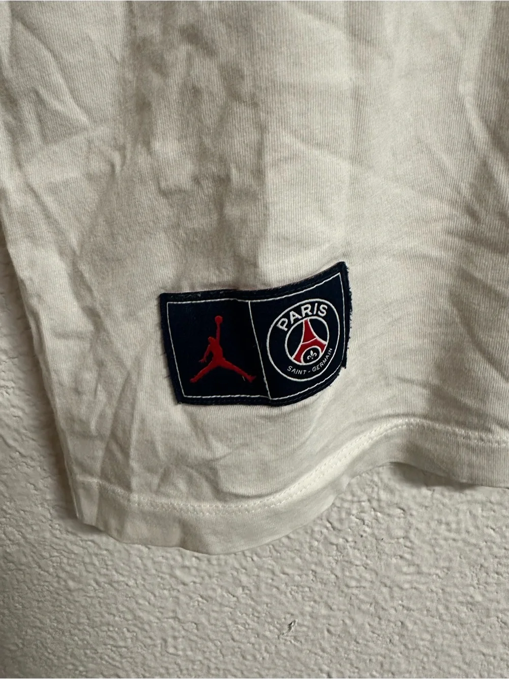 Jordan Paris Saint-Germain Cream Graphic Tee with Red and Black Logo